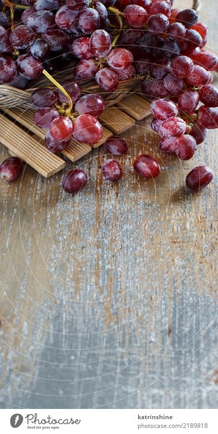 Red grapes on an old wooden table close up Fruit Nutrition Table Autumn Wood Dark Fresh Retro Agriculture Berries Food Bunch of grapes Grape vine Grapevine