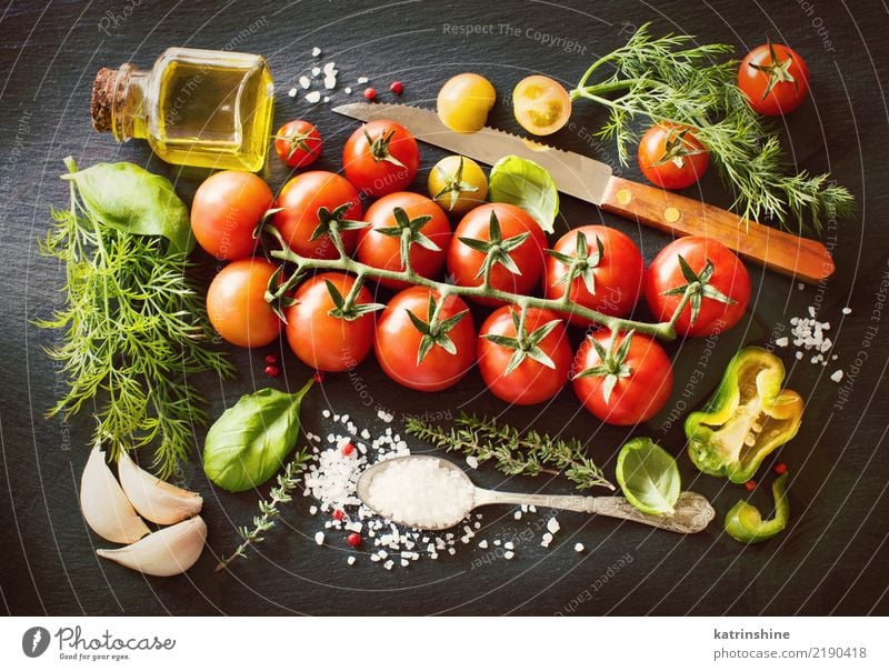 Cherry tomatoes, herbs and olive oil on a dark board Vegetable Vegetarian diet Diet Bottle Spoon Table Leaf Dark Fresh Bright Natural Green Red cook cooking