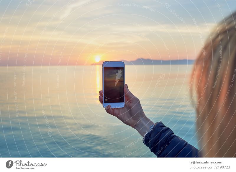 Young woman taking a photo of a colorful ocean sunset Vacation & Travel Sightseeing Summer Sun Ocean Cellphone PDA Camera Technology Woman Adults 1 Human being