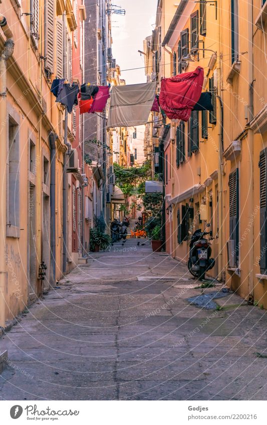 View into an alley with laundry on a clothesline between the houses Kérkira Corfu Capital city Old town House (Residential Structure) Facade Motorcycle Scooter