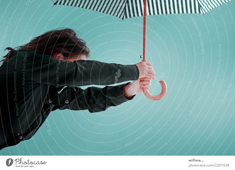 Woman with umbrella against a neutral background Adults 1 Human being Weather Gale Rain Umbrella Brunette Turquoise Striped Wind Upper body Copy Space
