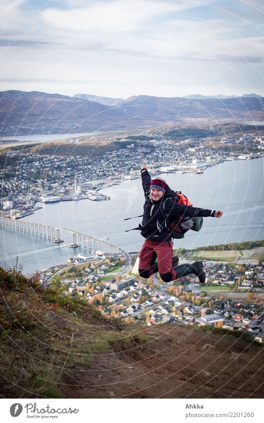 Young woman jumps cheerfully over the fjord of Tromsø Vacation & Travel Adventure Mountain Hiking Study Youth (Young adults) Landscape Fjord Port City Skyline
