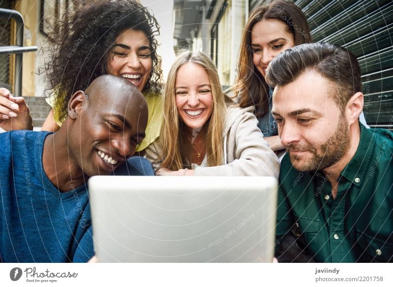 Multiracial young people looking at a tablet computer Lifestyle Joy Happy Beautiful Woman Adults Man Friendship Group Street Clothing Smiling Laughter Together