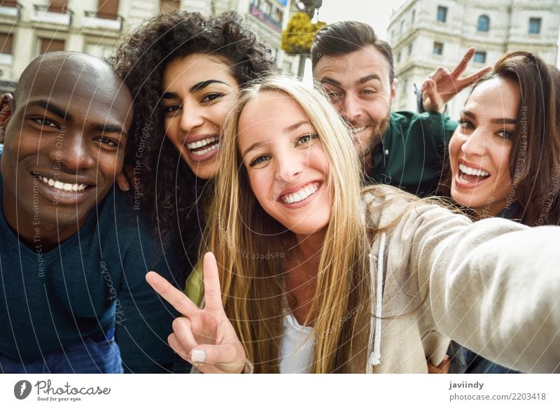 Multiracial group of friends taking selfie in a urban ...