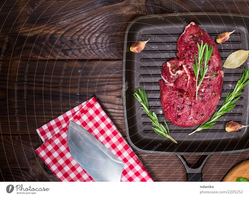 raw beef steak in spices Meat Herbs and spices Dinner Pan Knives Fork Table Kitchen Paper Wood Eating Fresh Green Red Meal pepper Beef Slice Chop Vantage point