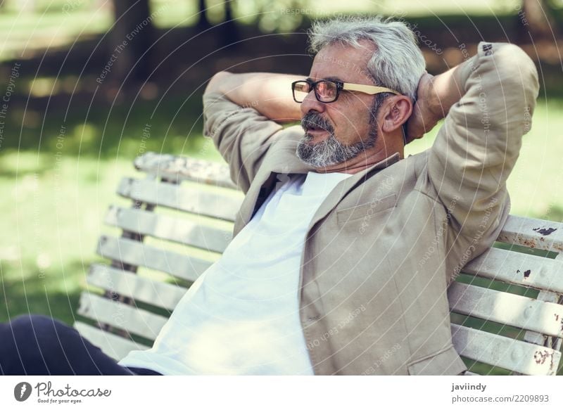 Portrait of a pensive mature man sitting on a bench in an urban park Lifestyle Happy Retirement Human being Masculine Man Adults Male senior 1 45 - 60 years