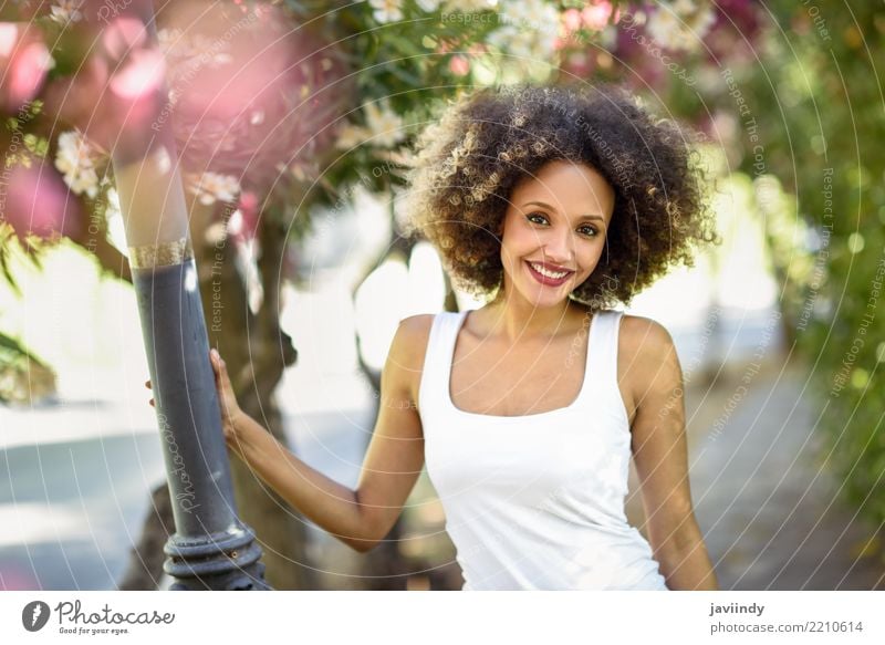 Mixed female with afro hairstyle smiling in urban park. Lifestyle Style Happy Beautiful Hair and hairstyles Face Summer Human being Feminine Young woman