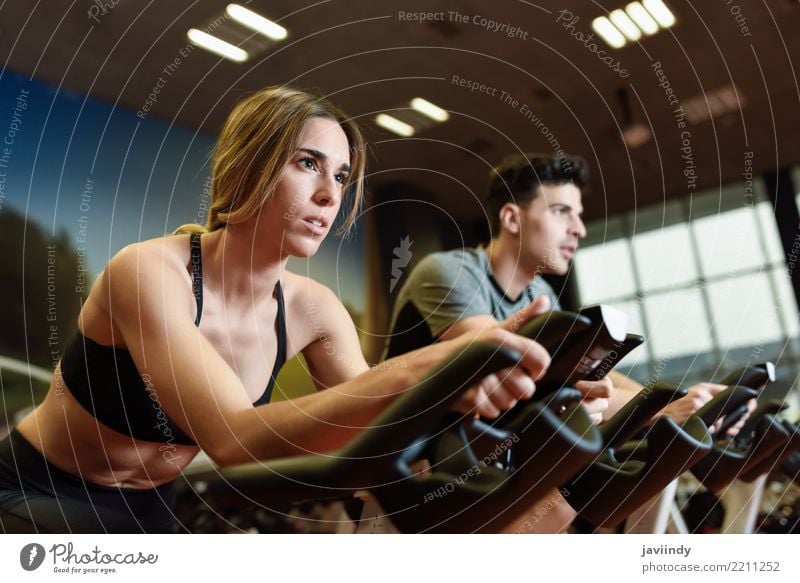 Couple in a spinning class wearing sportswear. Cyclo indoor. Lifestyle Leisure and hobbies Sports Work and employment Human being Masculine Feminine Woman
