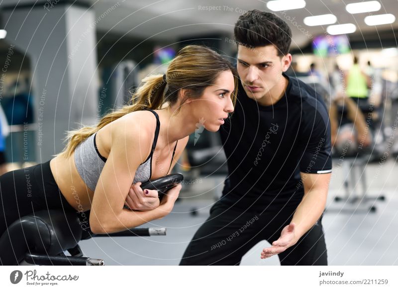 Personal trainer helping young woman lift weights Lifestyle Body Sports Human being Masculine Woman Adults Man 2 18 - 30 years Youth (Young adults) Railroad