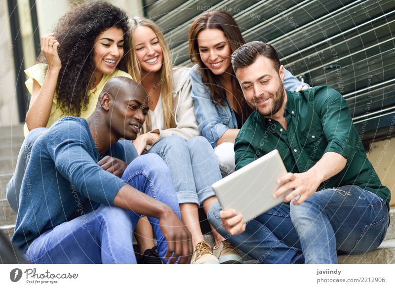 Multiracial group looking at a tablet computer outdoors Lifestyle Joy Happy Beautiful Human being Masculine Feminine Woman Adults Man Friendship 5 Group
