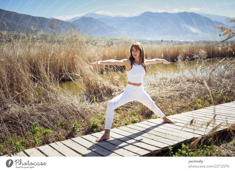 Young woman doing yoga in Nature. Lifestyle Beautiful Wellness Relaxation Meditation Summer Sports Yoga Human being Woman Adults Fitness Thin White Warrior pose