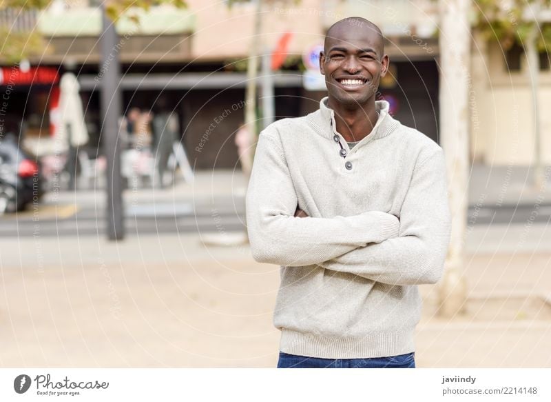 Black young man with arms crossed smiling in urban background Lifestyle Happy Beautiful Face Human being Man Adults 1 18 - 30 years Youth (Young adults) Street