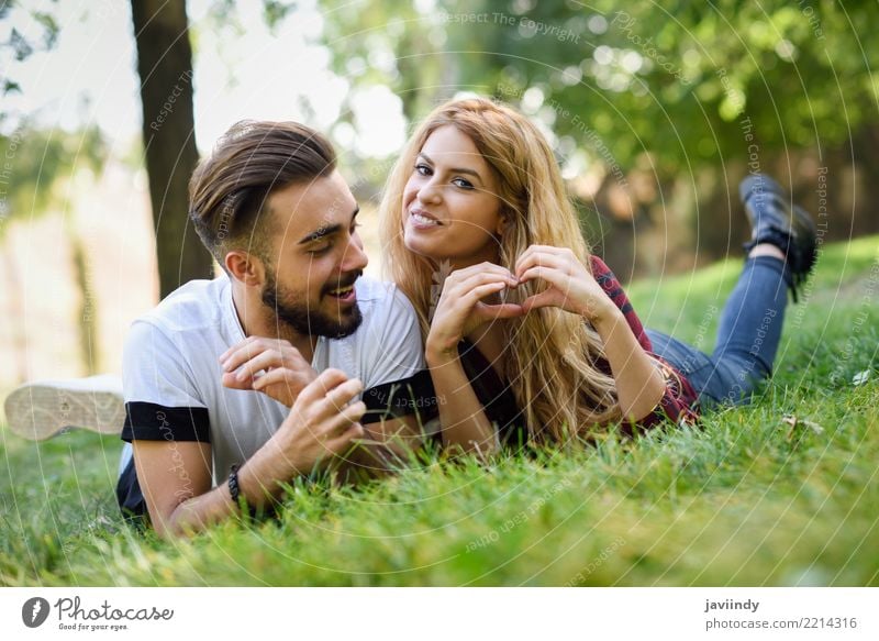 Beautiful young couple laying on grass in an urban park. Lifestyle Joy Happy Summer Human being Masculine Feminine Woman Adults Man Couple 2 18 - 30 years