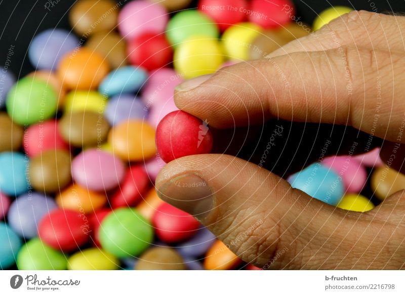 The Red Candy Healthy Alternative medicine Man Adults Hand Fingers To hold on Multicoloured Chocolate buttons Pill Addiction Take Select Selection Colour photo