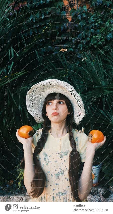 Young retro woman holding persimmons Food Fruit Nutrition Vegetarian diet Human being Feminine Young woman Youth (Young adults) 1 18 - 30 years Adults