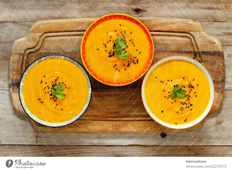 Fresh pumpkin soup in three bowls on a wooden table Vegetable Soup Stew Vegetarian diet Bowl Table Thanksgiving Hallowe'en Autumn Delicious Yellow Colour fall