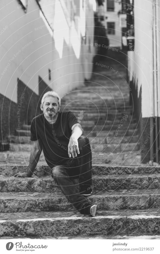 Portrait of a mature man sitting on steps in the street. Lifestyle Happy Human being Masculine Man Adults Male senior 1 45 - 60 years Street Clothing Beard Old