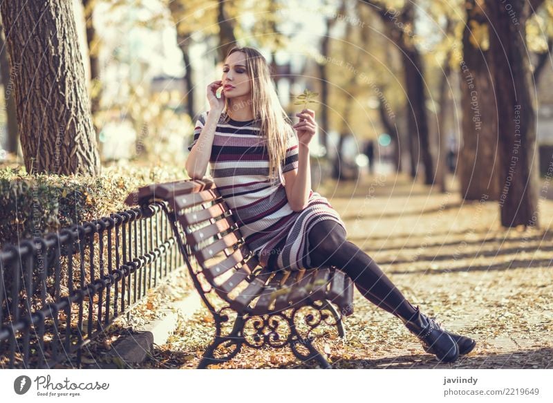 Young blonde woman sitting on a bench in the street Lifestyle Elegant Style Beautiful Hair and hairstyles Human being Feminine Young woman Youth (Young adults)