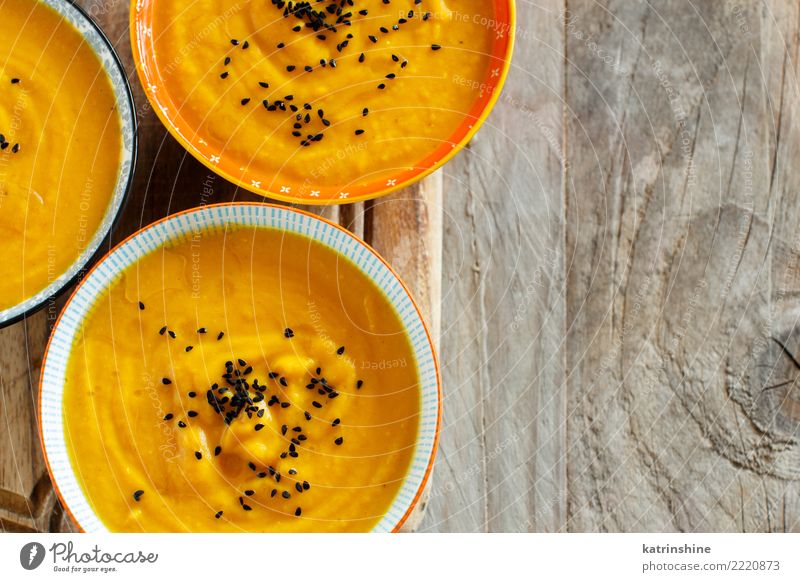 Fresh pumpkin soup in three bowls on a wooden table Vegetable Soup Stew Vegetarian diet Bowl Table Thanksgiving Hallowe'en Autumn Delicious Yellow Colour fall