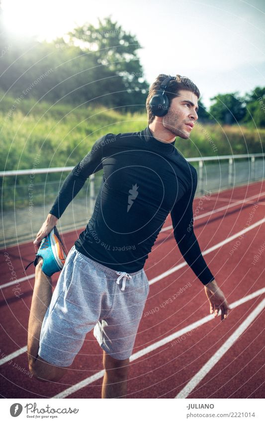 Young man doing stretching at runningtrack with headphones Drinking water Lifestyle Joy Body Healthy Healthy Eating Health care Athletic Muscular Fitness