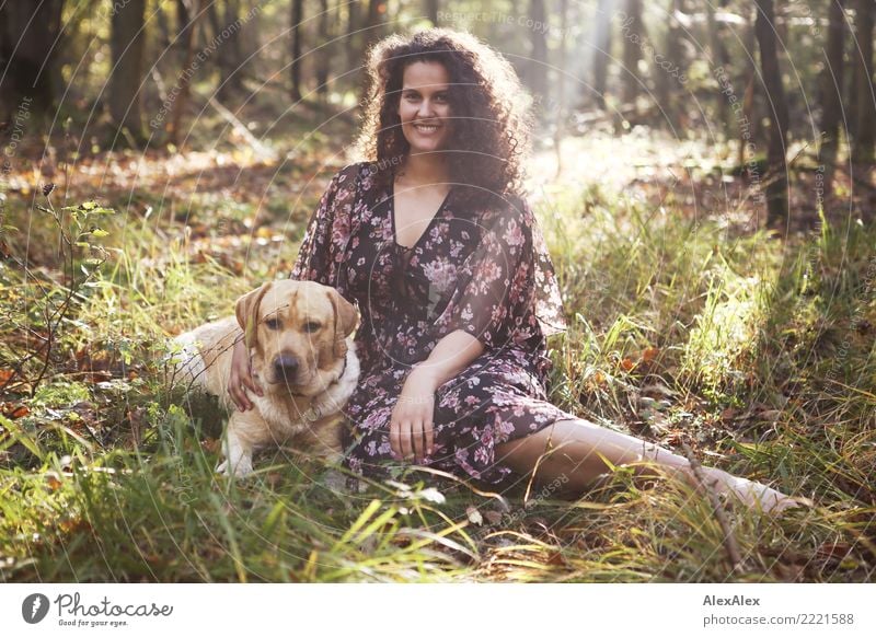 Portrait of young blonde Labrador and tall beautiful woman with long dark curly hair in forest Happy pretty Well-being Relaxation Trip Adventure Young woman
