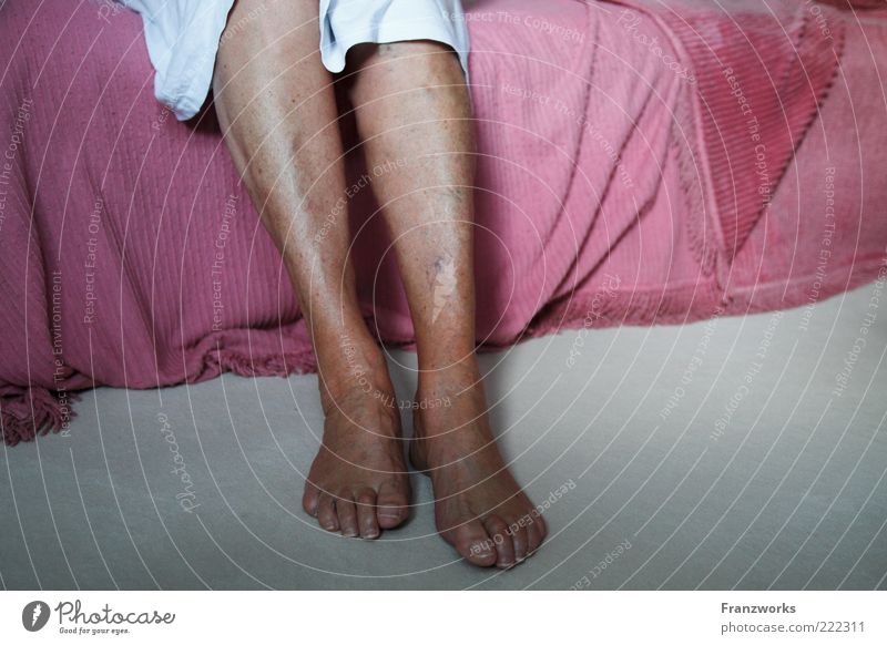 Close up of woman female feet in pink socks on a bed in bedroom