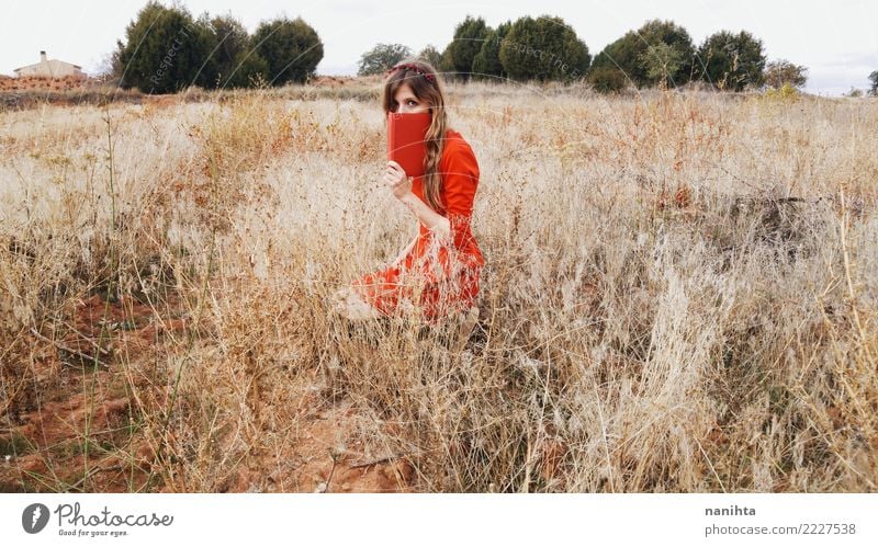 Young woman in a field with a red dress Lifestyle Style Harmonious Relaxation Human being Feminine Youth (Young adults) 1 18 - 30 years Adults Art Culture Book