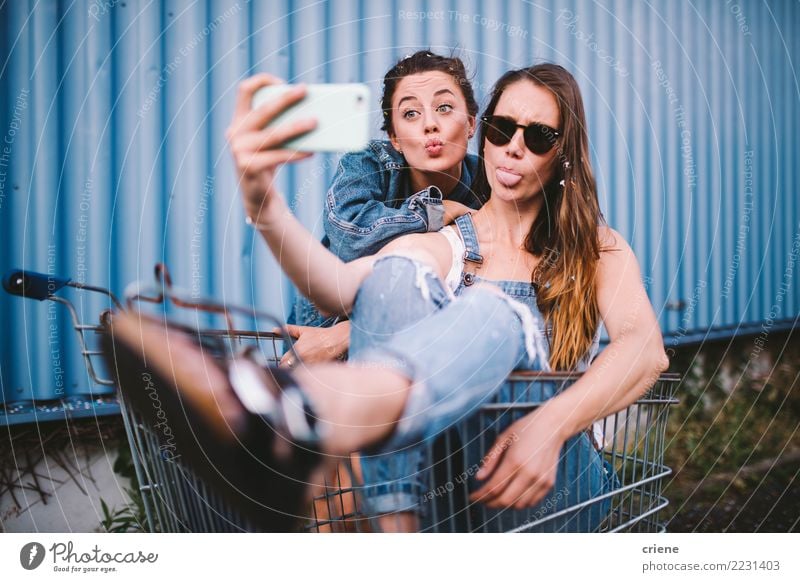 Young adult hipster girlfriends taking selfie and pulling faces Lifestyle Shopping Joy Happy Face Leisure and hobbies Summer Telephone Technology Woman Adults