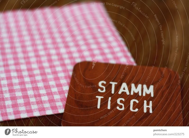 Beer mat with imprint Stammtisch on checked napkin and wooden table Table Village Characters Esthetic Exceptional Uniqueness Kitsch Brown Pink