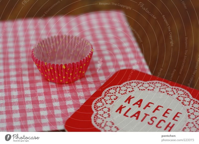 Beer mat with imprint Kaffeeklatsch on pink checked napkin and wooden table. Cupcake mould Style Esthetic Hip & trendy Kitsch Brown Pink Coffee break papery
