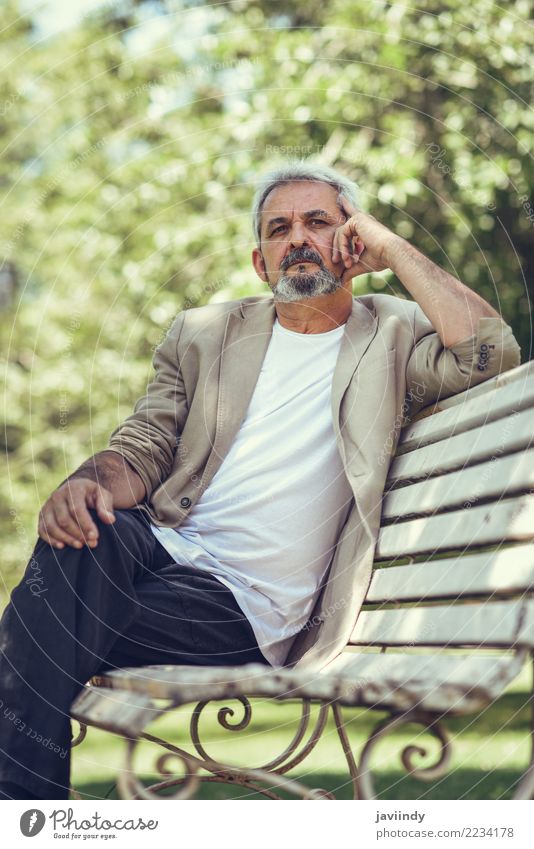 Pensive mature man sitting on a bench in an urban park. Lifestyle Happy Retirement Human being Masculine Man Adults Male senior 1 45 - 60 years