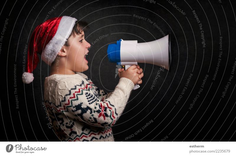 boy with a megaphone at christmas on black background Lifestyle Joy Entertainment Party Event Feasts & Celebrations Christmas & Advent New Year's Eve