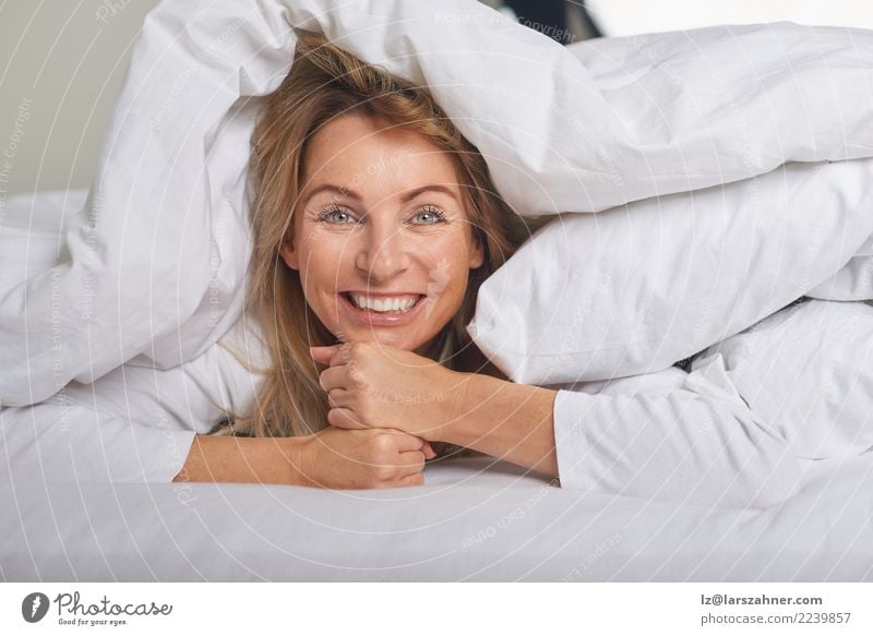 Beautiful middle-aged woman under sheets Happy Skin Face Relaxation Bedroom Woman Adults 1 Human being 45 - 60 years Blonde Smiling Sleep Happiness Under Soft