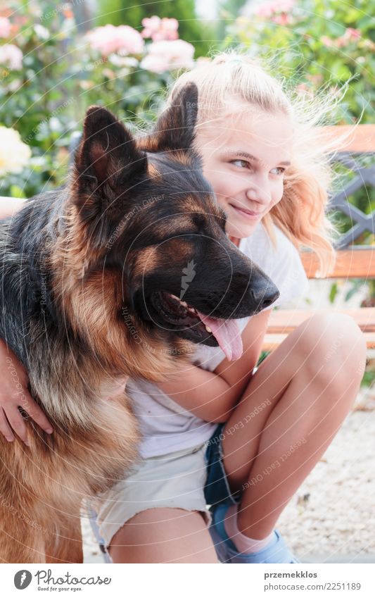 Young smiling girl squatting in the garden and hugging her dog Happy Summer Human being Girl Woman Adults Friendship 1 13 - 18 years Youth (Young adults) Animal