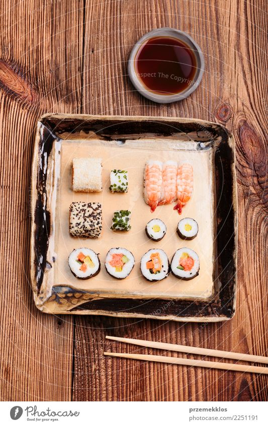 Sushi set on pottery plate with chopsticks and soy sauce Food Seafood Lunch Plate Table Wood Rust Fresh Delicious Above Tradition ceramic Chopstick Cooking