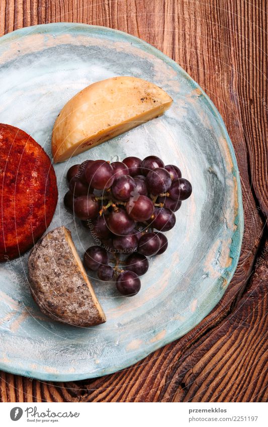Cheese and black grapes on handmade blue pottery plate Food Fruit Breakfast Plate Table Wood Rust Fresh Delicious Above ceramic Cooking Gourmet Bunch of grapes