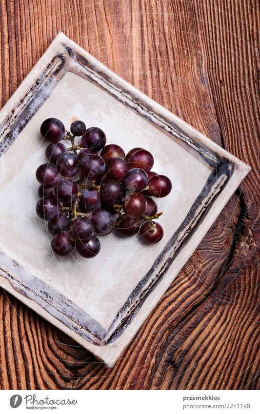 Black grapes on handmade square pottery plate Food Fruit Diet Plate Table Wood Rust Fresh Delicious Above ceramic Cooking Gourmet Bunch of grapes healthy
