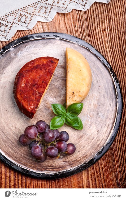 Cheese and black grapes on handmade pottery plate Food Fruit Nutrition Breakfast Plate Table Wood Rust Fresh Delicious Above ceramic Cooking Gourmet