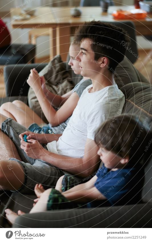 Concentrated young boy and girl playing video games sitting on sofa at home Lifestyle Joy Leisure and hobbies Playing Sofa Child Technology Toddler Girl