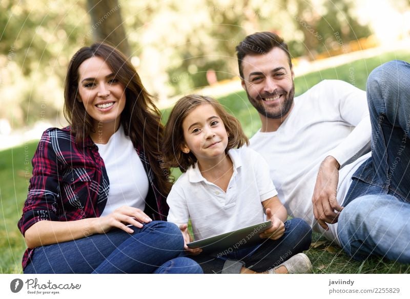 Happy family in a urban park playing with tablet computer Lifestyle Joy Beautiful Playing Summer Child Computer Technology Girl Woman Adults Man Parents Mother