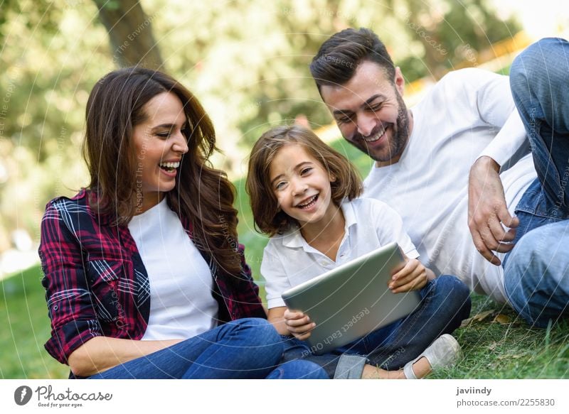Happy family in a urban park playing with tablet computer Lifestyle Joy Beautiful Playing Summer Child Computer Technology Human being Masculine Feminine Girl