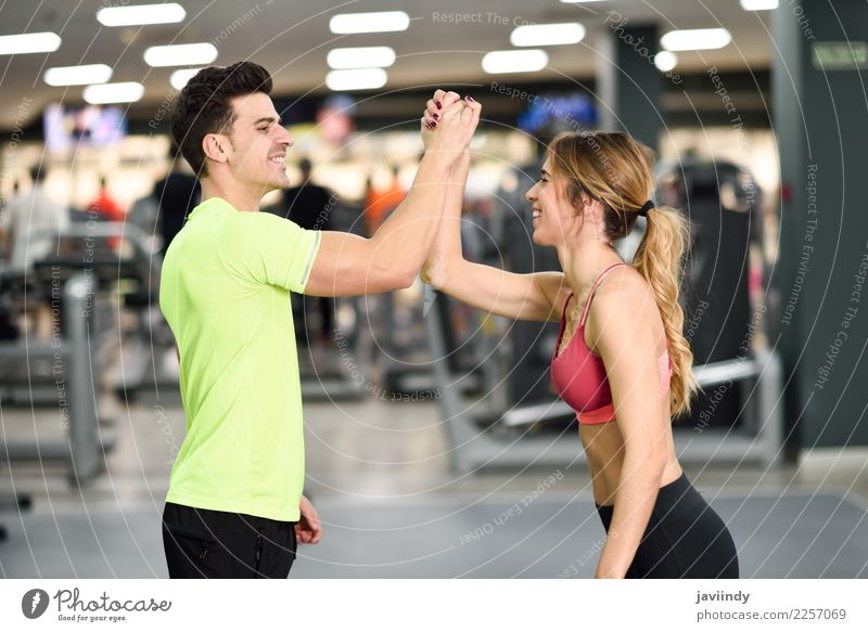 Smiling young man and woman doing high five in gym Lifestyle Happy Body Wellness Feasts & Celebrations Sports Success Human being Masculine Feminine Young woman