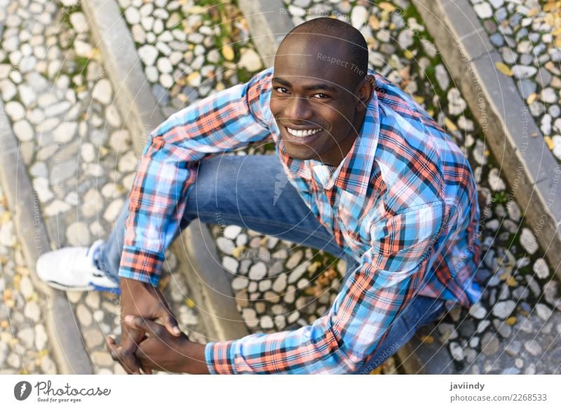 Black man smiling and sitting in urban steps Happy Beautiful Human being Masculine Young man Youth (Young adults) Man Adults 1 18 - 30 years Street Clothing