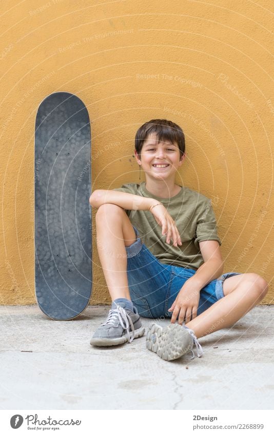 A smiling boy with skateboard sitting alone on the floor Lifestyle Joy Relaxation Freedom Summer Sun Child Cellphone PDA Human being Boy (child) Man Adults