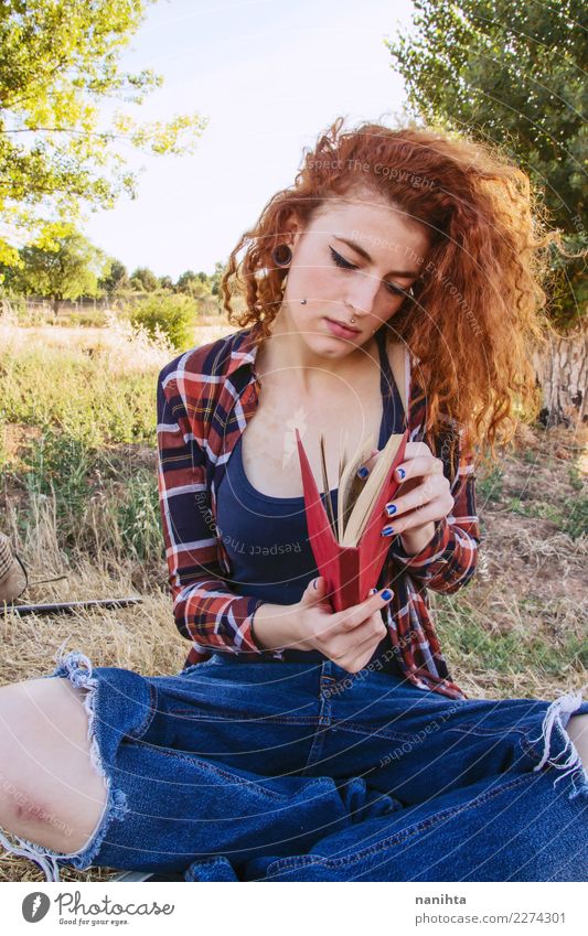 Young woman is opening a book, outdoors . Lifestyle Beautiful Senses Calm Leisure and hobbies Reading Study Student Human being Feminine Youth (Young adults) 1