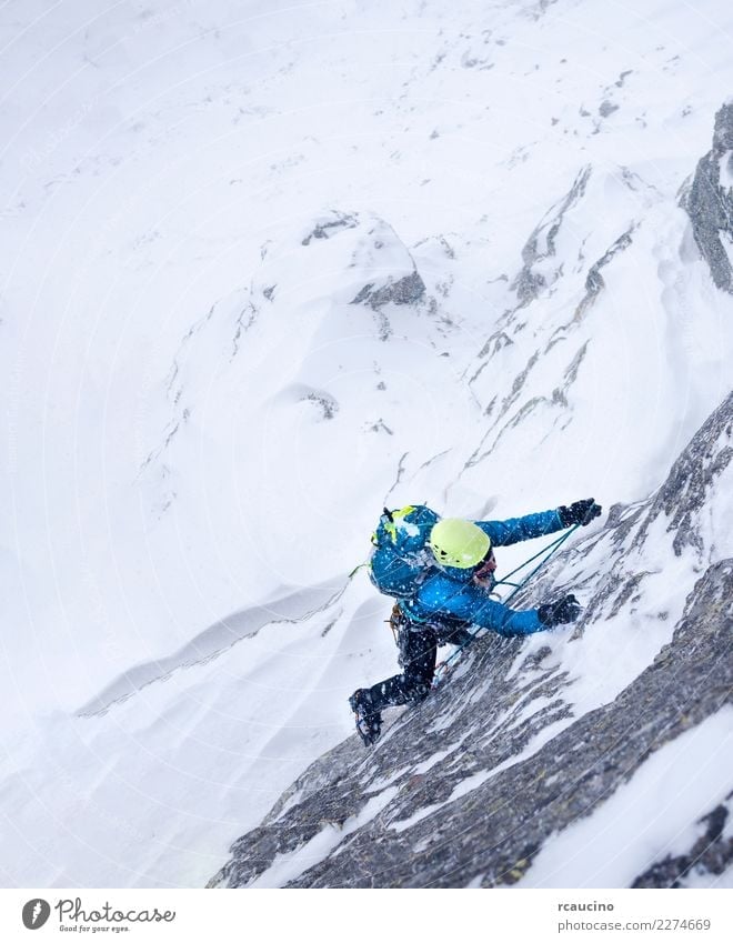 Female climber in the storm during an extreme winter climb Adventure Expedition Winter Snow Mountain Sports Climbing Mountaineering Success Woman Adults Storm