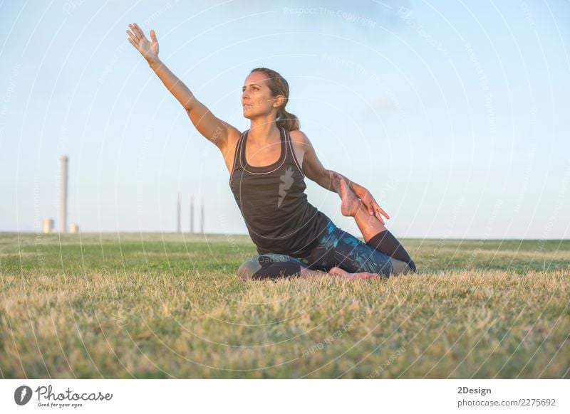 Beautiful girl is engaged in yoga in the park Lifestyle Harmonious Relaxation Sports Yoga Woman Adults Youth (Young adults) Nature Grass Park Sit Green Power