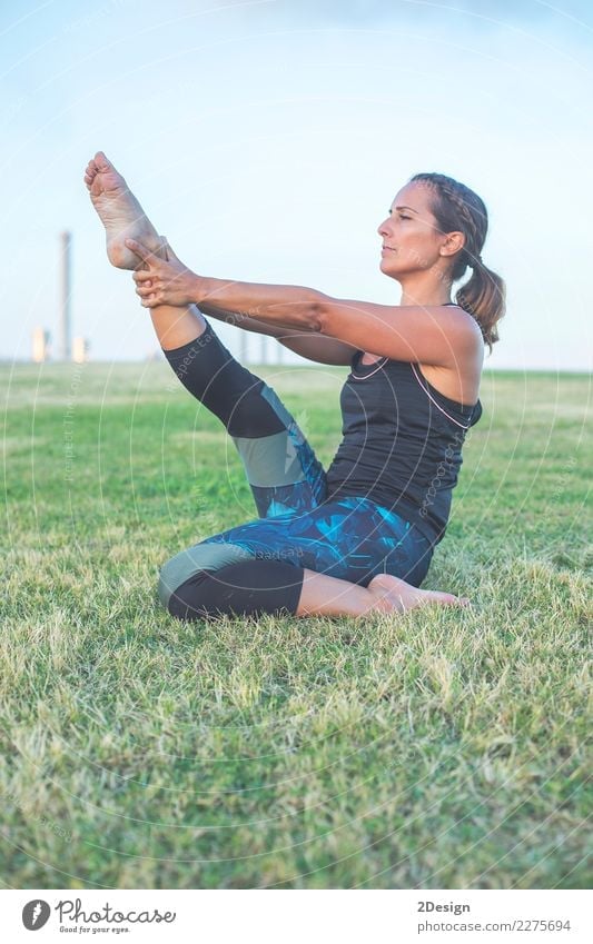 Beautiful girl is engaged in yoga in the park Lifestyle Harmonious Relaxation Sports Yoga Woman Adults Youth (Young adults) Nature Grass Park Sit Green Power