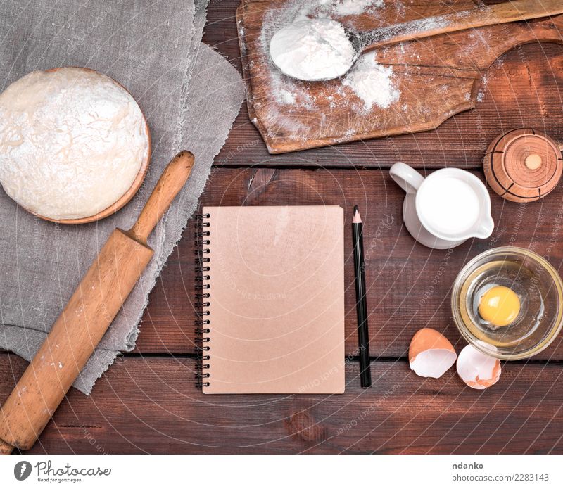 dough and ingredients Dough Baked goods Bread Bowl Table Kitchen Paper Wood Eating Fresh Natural Above Brown White Pencil notebook recipe Menu Rolling pin Yeast
