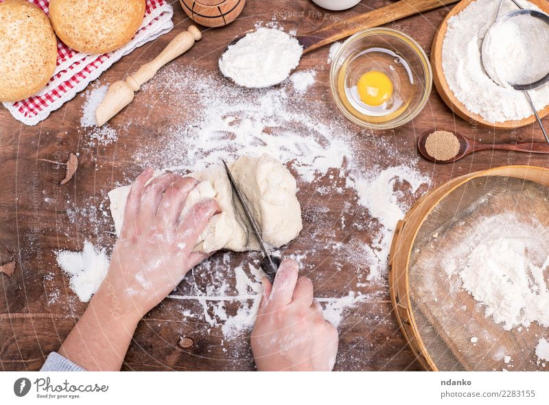 female hands cut with a knife yeast dough Dough Baked goods Bread Roll Bowl Body Table Kitchen Woman Adults Arm Hand Sieve Wood Make Fresh Natural Above Brown